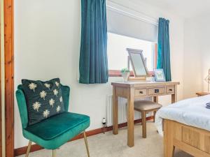 a bedroom with a bed and a desk and a chair at Craigievar in Cruden Bay