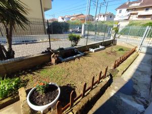 a garden with flowers in a flower bed with a fence at Le Due Sorelle in Porto SantʼElpidio