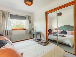 a bedroom with two beds and a mirror at Craigievar in Cruden Bay