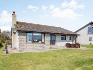 a stone house with a picnic table in the yard at Craigievar in Cruden Bay