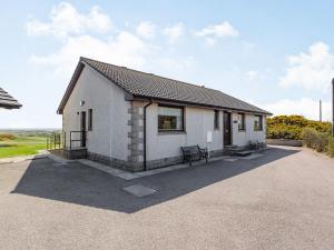 a white house with a bench in front of it at Craigievar in Cruden Bay