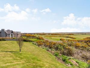 a house on a golf course with a green at Craigievar in Cruden Bay