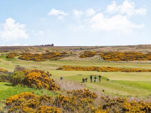 a group of people walking on a golf course at Craigievar in Cruden Bay