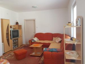 a living room with a red couch and a tv at Kragić apartman in Soko Banja