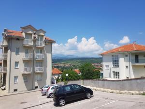a car parked in a parking lot between two buildings at Kragić apartman in Soko Banja