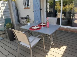a table and chairs on a porch with a bottle of wine at Bord Verdon T2 Maisonnette 35m2 Climatisation - Terrasse 25m2-classé 3étoiles in Gréoux-les-Bains