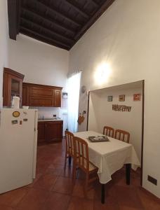 cocina con mesa y nevera blanca en al Vicolo Torlonia, en Tívoli