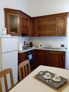 una cucina con frigorifero bianco e tavolo con sedie di al Vicolo Torlonia a Tivoli
