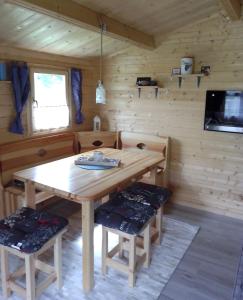 comedor con mesa de madera y sillas en Schlaffass und Hütte mit Teich, en Klöch