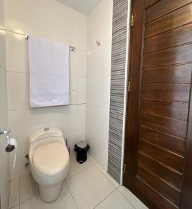 baño con aseo y puerta de madera en Apartamento La Cusqueñita, en Cusco