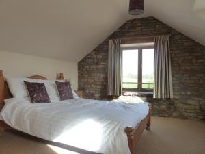 Un dormitorio con una cama grande y una ventana en The Barn at Freemans Farm, en Alveston