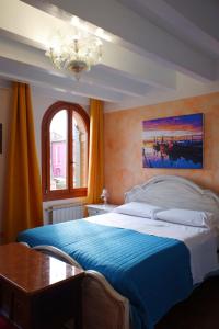 a bedroom with a large bed with a blue blanket at Cà di Pizzo di Burano in Burano
