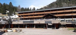 a large building with a parking lot in front of it at Casa MARGHERITA Rainalter in Madonna di Campiglio