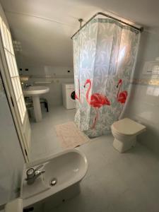 a bathroom with a toilet and a shower curtain at Casa Antonella in Porto Azzurro