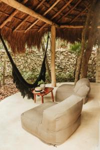 a large bird sitting on top of a wooden bench at Papaya Playa Project in Tulum