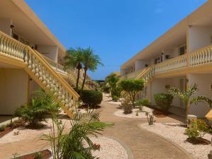 a courtyard of a hotel with stairs and plants at Montana Eco Resort Aruba in Oranjestad