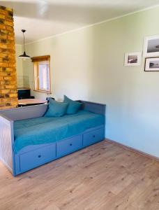 ein Schlafzimmer mit einem blauen Bett in einem Zimmer in der Unterkunft Lūšių vėjas in Palūšė