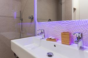 bagno con lavandino bianco e specchio di SeaPark SPA Resort a Giulianova