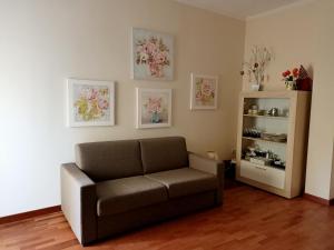 uma sala de estar com um sofá e uma prateleira com flores em La mia Casa em Nápoles