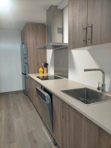 a kitchen with wooden cabinets and a sink at Alojamiento Costas Bueu in Bueu