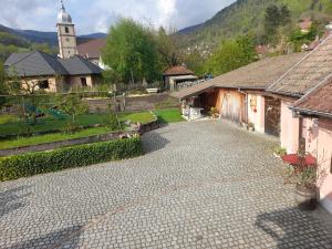 a cobblestone street in a village with a church at Charmant petit appartement avec bel exterieur. in Saint-Amarin