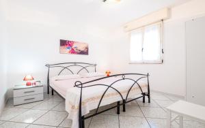 um quarto branco com uma cama e uma janela em Dimora Giusy Vista Mare Pescoluse em Marina di Pescoluse
