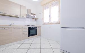 uma cozinha branca com um fogão e uma janela em Dimora Giusy Vista Mare Pescoluse em Marina di Pescoluse