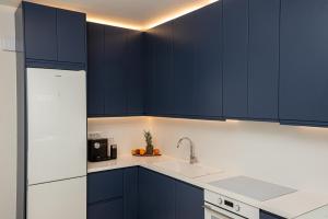 a kitchen with navy blue cabinets and a sink at G&J Deluxe Apt in Zakynthos Town