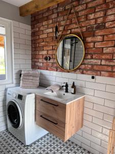 a bathroom with a washing machine and a mirror at Domek pod Dębem in Szymonowo +40 photos