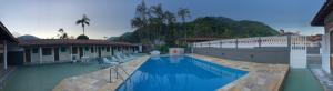 a large swimming pool next to a building at Hotel Pousada Nosso Cantinho in Ubatuba