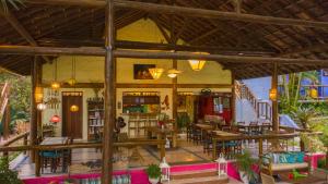 a restaurant with tables and chairs in a room at Atmosphera Pousada in Arraial d'Ajuda