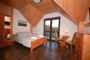 a bedroom with a bed and a table and chairs at Agroturystyka Nad Stawem in Górno