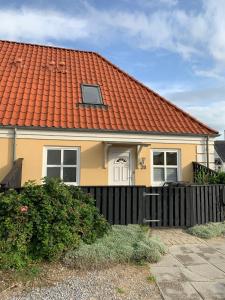 une maison jaune avec un toit orange dans l'établissement 4 personers ferielejlighed, à Løkken