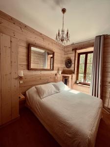 een slaapkamer met een bed en een kroonluchter bij BO LODGE in Le Bourg-dʼOisans