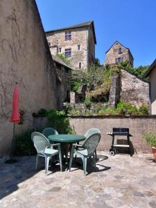 a patio with a green table and chairs at 11 rue basse Najac in Najac