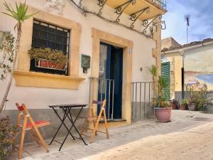 a table and chairs in front of a building at Dimore Sicule Noto in Noto