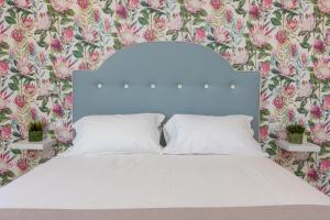 TorcaVilla Maìki的卧室配有白色床和花卉壁纸