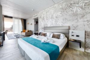 una camera da letto con un grande letto con una coperta blu di Vision Hotel a Peschiera del Garda