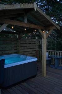 un jacuzzi sur une terrasse en bois avec une pergola dans l'établissement Luxurious Cottage with hot tub, Lake District, à Duddon