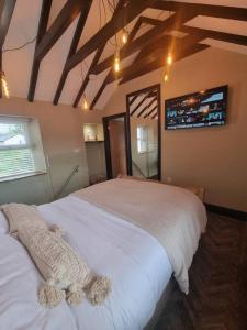 une chambre avec un grand lit blanc dans une pièce dans l'établissement Luxurious Cottage with hot tub, Lake District, à Duddon