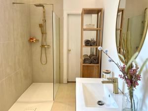 a bathroom with a shower and a sink and a mirror at Stylish & Chic Central Apartment with Hot Tub in Perth