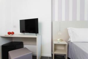 a bedroom with a desk with a tv and a bed at Hotel Star in Cesenatico