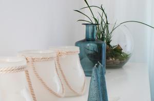 a table with two white containers and a blue vase at IRS ROYAL APARTMENTS Apartamenty IRS Nadmorze in Gdańsk