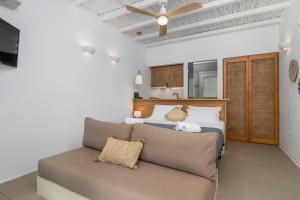 1 dormitorio con 1 cama y 1 sofá en Vilos Suites Fyropotamos Beach en Firopótamos