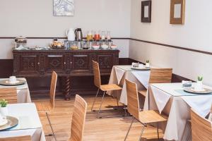 une salle à manger avec des tables et des chaises ainsi qu'un buffet dans l'établissement Hostal Lirium, à Arequipa