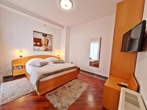 a bedroom with a bed and a flat screen tv at Hotel Sunce in Podstrana