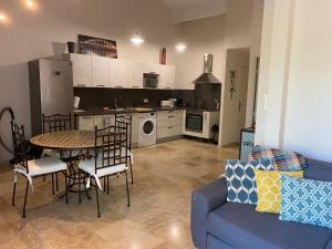 eine Küche und ein Wohnzimmer mit einem Tisch und einem blauen Sofa in der Unterkunft Green village in Roquebrune-sur-Argens