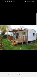 a small house with a porch and a deck at Camping Siblu les Charmettes la Palmyre in Les Mathes