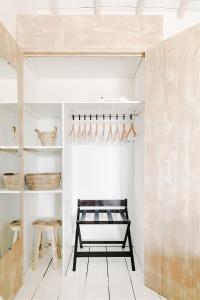 a room with a bench and a wall with shelves at Hôtel Restaurant Les Arnelles in Saintes-Maries-de-la-Mer