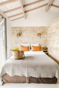 a bedroom with a large bed with orange pillows at Hôtel Restaurant Les Arnelles in Saintes-Maries-de-la-Mer